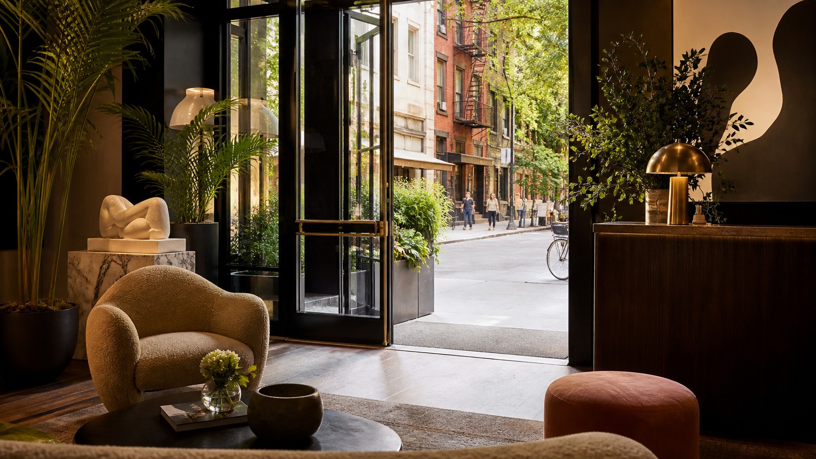 Stylish boutique hotel lobby opening onto a leafy major city street